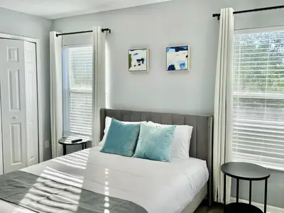a bedroom with a bed with blue pillows and a window at Family Retreat 6BR Villa with Private Pool, Spa & Theater near Disney in Kissimmee