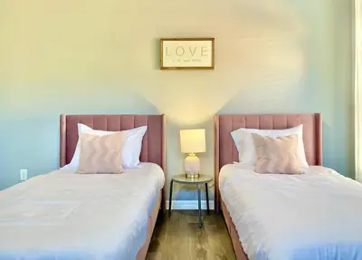 two beds sitting next to each other in a room at Family Retreat 6BR Villa with Private Pool, Spa & Theater near Disney in Kissimmee