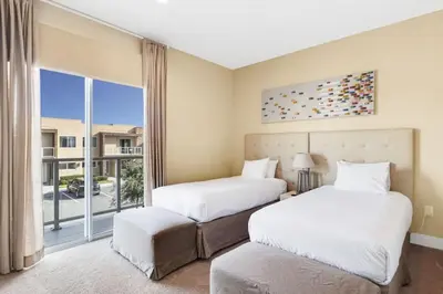 two beds in a room with a window at Luxury Townhouse located NEXT to DISNEY ORLANDO in Orlando