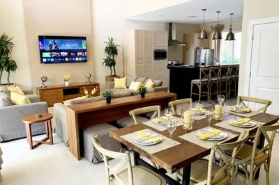 a dining room and living room with a table and chairs at Luxury Townhouse located NEXT to DISNEY ORLANDO in Orlando