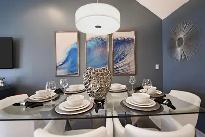a dining room with a glass table and white chairs at Beautiful 3-Bed Villa 10 Minutes From Disney - Serenity Resort townhouse in Orlando