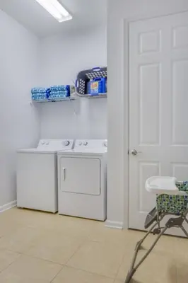 a white kitchen with a stove and a chair at Penthouse Utopia condo in Orlando