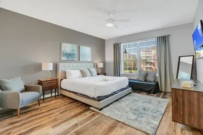 a bedroom with a bed and a couch and a window at Vista Cay Magic condo in Orlando