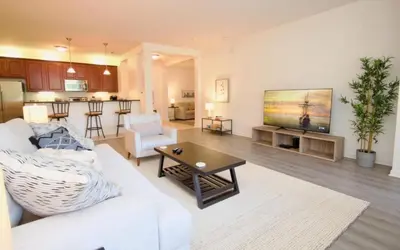 a living room with a white couch and a tv at NEW! Vista Cay Luxury Mirage condo in Orlando