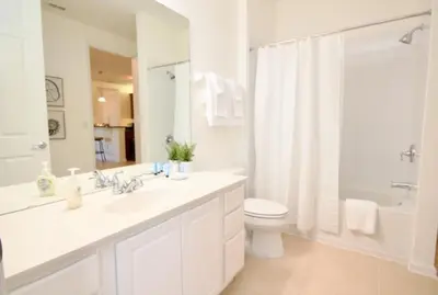 a white bathroom with a sink and a toilet and a shower at NEW! Vista Cay Luxury Mirage condo in Orlando