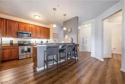 a kitchen with wooden cabinets and a kitchen island with bar stools at Vista Cay Electra condo in Orlando