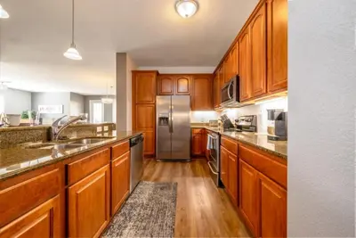 a kitchen with wooden cabinets and a stainless steel refrigerator at Vista Cay Electra condo in Orlando