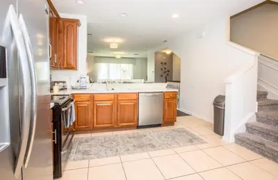 a kitchen with wooden cabinets and a stainless steel refrigerator at Vista Cay Casa Bonita townhouse in Orlando