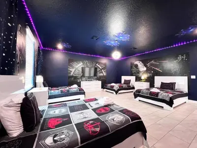 a room with three beds and a tv in it at 8 Bed Storey Lake Resort- Huge Bedroom for Kids home in Kissimmee