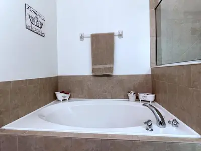 a large bath tub in a bathroom with a sink at Cozy 4 Bed 3 Bath Private Pool Home with Game Room home in Kissimmee