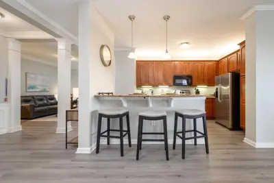 a kitchen with a counter and bar stools at Vista Cay Lakeview Elysium condo in Orlando