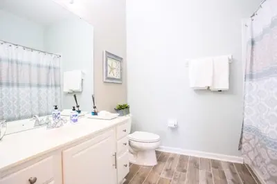 a bathroom with a toilet and a sink and a shower at LakeView Penthouse Elegance condo in Orlando