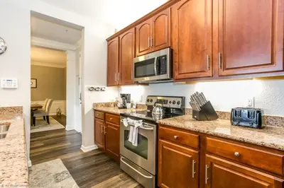 a kitchen with wooden cabinets and a stove top oven at Lake View 3 Bedroom In Vista Cay Resort condo in Orlando