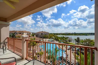 a balcony with a view of a resort and a lake at Pool View Penthouse condo in Orlando