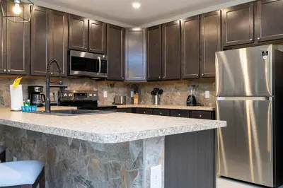 a kitchen with wooden cabinets and a stainless steel refrigerator at Stunning 3Bd Close to Disney at Fiesta Key 4764 in Kissimmee