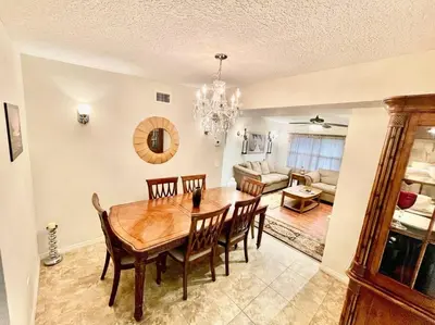 a dining room with a wooden table and chairs at Cozy Modest Home near Universal Studios/VolcanoBay in Orlando