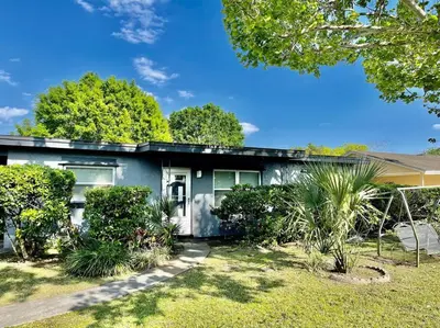 a gray house with bushes in front of it at Cozy Modest Home near Universal Studios/VolcanoBay in Orlando