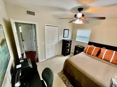 a bedroom with a bed and a ceiling fan at Cozy Modest Home near Universal Studios/VolcanoBay in Orlando