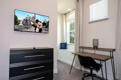 a room with a desk and a tv on the wall at Marvelous 3Bd w Pool Near Disney at Serenity 1536 in Orlando