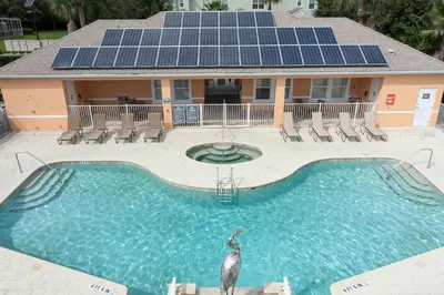 a house with a swimming pool with solar panels on it at Marvelous 3Bd w Pool Near Disney at Serenity 1536 in Orlando