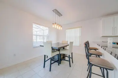 a kitchen and dining room with a table and chairs at 606 - Stunning 5 bed vacation rental home with private pool in Kissimmee