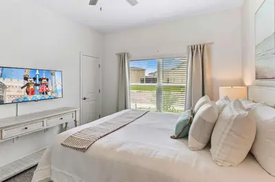 a white bedroom with a large bed and a window at 4423 Scene Lane in Kissimmee