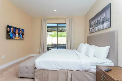 a bedroom with a large white bed and a window at Magical 4suites Home w jacuzzi near Disney 7497 in Orlando