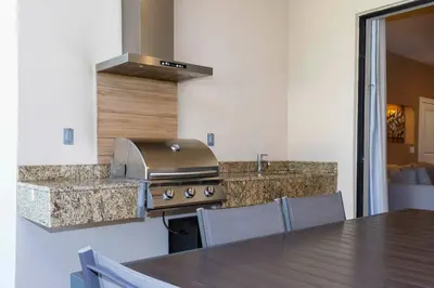 a kitchen with a stove and a table with chairs at Magical 4suites Home w jacuzzi near Disney 7497 in Orlando