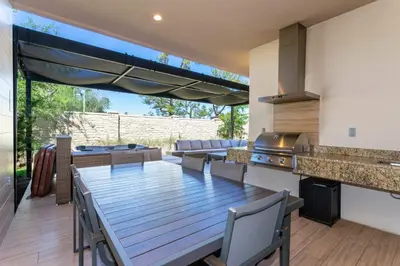 an outdoor dining room with a table and a kitchen at Magical 4suites Home w jacuzzi near Disney 7497 in Orlando