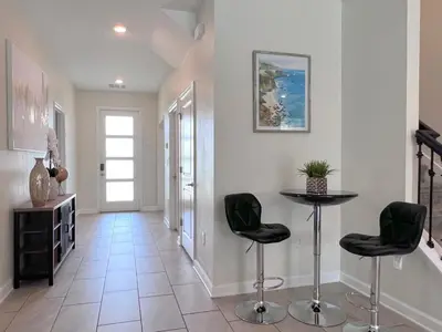 a hallway with two chairs and a table in it at Spacious Home with Fun Decore and Game Room-4544TB in Kissimmee