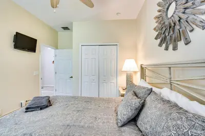 a bedroom with a bed and a flat screen tv at 10 Mi to Disney Home with Game Room and Lanai! in Kissimmee