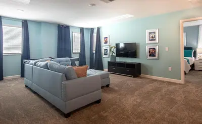 a living room with a couch and a television at 820DSD - The Retreat at ChampionsGate home in Orlando