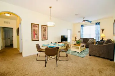 a living room with a table and a couch at Vista Cay - Cosy 3 bedroom condo in Orlando