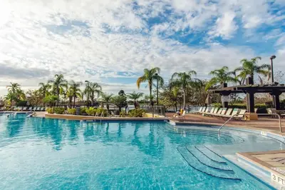 a swimming pool at a resort with palm trees at Vista Cay - Cosy 3 bedroom condo in Orlando