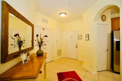 a room with a mirror and a vase with flowers on a table at Vista Cay - Cosy 3 bedroom condo in Orlando