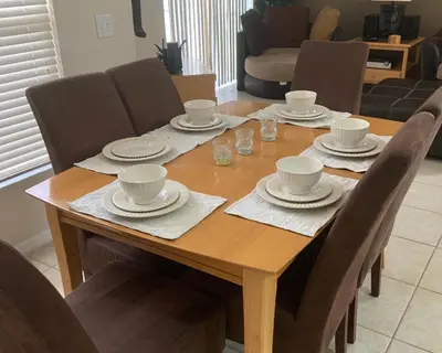 a wooden table with cups and saucers on it at Emerald Escape - New Pool Home in Kissimmee