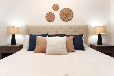a bedroom with a white bed with pillows and two lamps at Exquisite First-Floor Condo, 7 Min to Disney in Kissimmee