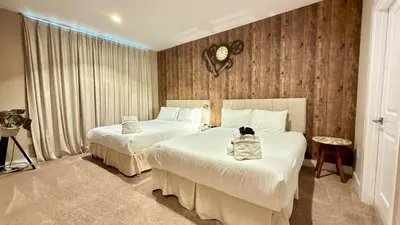 a hotel room with two beds with a cat sitting on them at Sophisticated 4 En Suites w Private Hot Tub & BB in Orlando