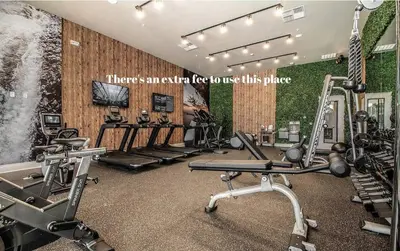 a gym with several treadmills and machines in a room at Sophisticated 4 En Suites w Private Hot Tub & BB in Orlando