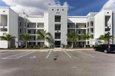 a parking lot in front of a large white building at Charming Holiday Condo, Only 7 min to Disney in Kissimmee