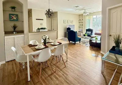 a dining room and living room with a table and chairs at 2BR2BA Getaway 7 Miles from Orlando Parks in Kissimmee