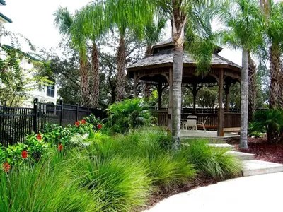 a gazebo in a garden with palm trees and flowers at 2BR2BA Getaway 7 Miles from Orlando Parks in Kissimmee