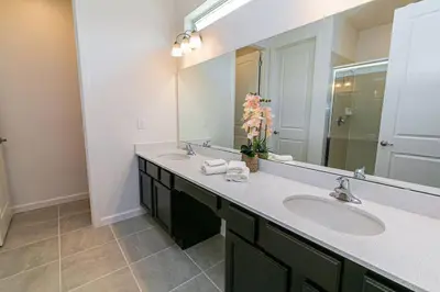 a bathroom with two sinks and a large mirror at ☀️12BR Disney Villa Paradise w/ Game Room & Pool/Spa☀️ in Kissimmee