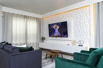 a living room with couches and a tv on a wall at Windsor Oasis 6BR Pool Game Room 9 min Disney in Orlando