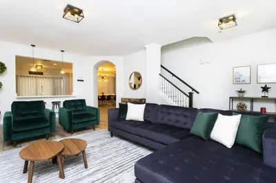 a living room with a blue couch and green chairs at Windsor Oasis 6BR Pool Game Room 9 min Disney in Orlando
