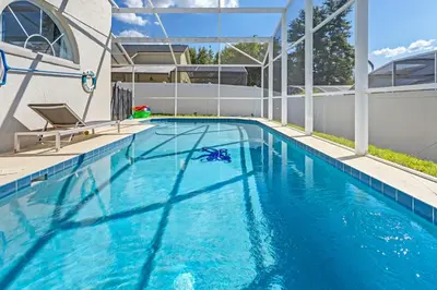 a swimming pool with blue water in a house at Amazing Pool Spacious 3BR House near Disney in Kissimmee