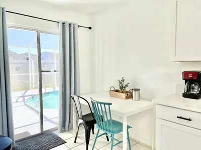 a kitchen with a table and chairs and a balcony at Beautiful 3BR House with Private Pool near Disney in Kissimmee