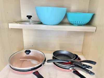 a shelf with two bowls and a pot and pans at Beautiful 3BR House with Private Pool near Disney in Kissimmee