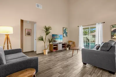 a living room with two couches and a tv at Amazing Blue Private Pool 4BR House Near Disney in Kissimmee