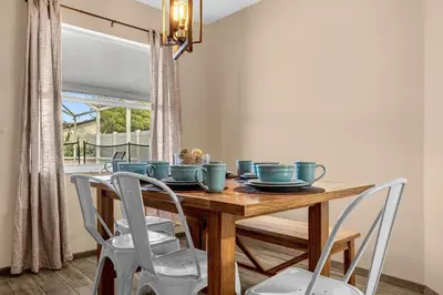 a dining room with a wooden table and chairs at Amazing Blue Private Pool 4BR House Near Disney in Kissimmee